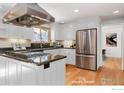 Modern white kitchen featuring stainless steel appliances, granite countertops, and hardwood floors at 330 Hopi Pl, Boulder, CO 80303