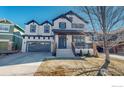 Charming two-story home with a covered front porch, gray garage door, and well-maintained landscaping at 3418 Fantasy Pl, Castle Rock, CO 80109