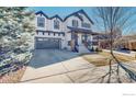 Attractive two-story home with a covered porch, long driveway, and mature landscaping on a sunny day at 3418 Fantasy Pl, Castle Rock, CO 80109