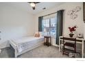 Cozy bedroom featuring a ceiling fan, a window with blinds, and a comfortable bed at 3575 Boulder Cir # 101, Broomfield, CO 80023