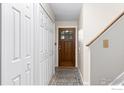 Hallway features a wooden door, white closet and wood floors with a patterned rug at 4434 Mast Rd, Boulder, CO 80301