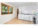 Cozy kitchen with bright window, white cabinets and appliances, and unique backsplash at 4434 Mast Rd, Boulder, CO 80301