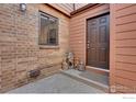 Townhome entrance with a brick and siding exterior, a brown front door, and cute bear decorations at 449 Wright St # 6, Lakewood, CO 80228