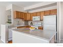 Well-lit kitchen with light wood cabinetry, stainless steel appliances, and a functional center island at 4501 Nelson Rd # 2303, Longmont, CO 80503