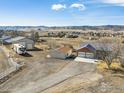 Aerial view of the home with multiple garages, RV parking, and mountain views at 4900 Beverly Dr, Berthoud, CO 80513