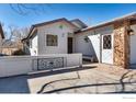 Charming home featuring stone accents, a side-entry door, and white privacy fence at 607 Cressman Ct, Golden, CO 80403