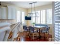 Well-lit dining area featuring a wooden table, patterned chairs, large windows, and a decorative pendant light fixture at 6425 Legend Ridge Trl, Niwot, CO 80503