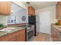 Cozy kitchen featuring stainless steel appliances, wooden cabinetry, and granite countertops at 720 W Dahlia St, Louisville, CO 80027