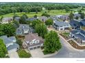 Aerial view of a residential neighborhood highlighting a home with a three-car garage near a golf course and pond at 809 Saint Andrews Ln, Louisville, CO 80027