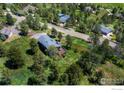 Overhead view of a home with a wooden deck nestled among trees near a quiet road at 8483 Thunderhead Dr, Boulder, CO 80302