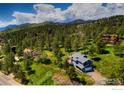 Aerial view of a charming home nestled in a picturesque mountain setting with lush greenery and scenic views at 8483 Thunderhead Dr, Boulder, CO 80302