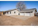 View of the home's exterior with a detached two-car garage and a large concrete driveway at 9752 Sierra Vista Rd, Longmont, CO 80504