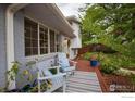 Cozy front porch with comfortable seating, colorful plants, and a view of the landscaped front yard at 1011 Vivian Cir, Boulder, CO 80303