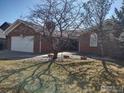 Attractive brick home with well-kept lawn and mature trees, with a spacious driveway at 1191 Twin Peaks Cir, Longmont, CO 80503