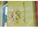 Close-up of house number 1324 with floral wreath on a green-painted wall at 1324 Snowberry Ln, Louisville, CO 80027