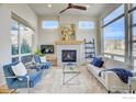 Bright living room featuring a modern fireplace, plush seating, and large windows at 1324 Snowberry Ln, Louisville, CO 80027