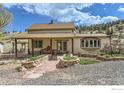 Inviting home featuring a covered porch, beautiful landscaping, and a stone walkway at 16450 Dakota Ridge Rd, Longmont, CO 80503