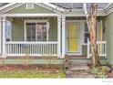 Inviting front porch with a swing, string lights, and a bright yellow front door, offering curb appeal at 1665 Bain Dr, Erie, CO 80516