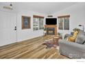 Bright living room with modern fireplace, hardwood floors, and a cozy seating area at 1665 Bain Dr, Erie, CO 80516