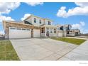 Beautiful two-story home with a brick-accented facade, covered porch, and spacious driveway at 1850 Sawtooth Mountain Dr, Berthoud, CO 80513