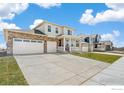 Charming two-story home featuring a brick accent, porch, manicured lawn, and a spacious three-car garage at 1850 Sawtooth Mountain Dr, Berthoud, CO 80513