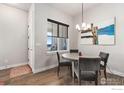 Cozy dining area featuring a round table, modern lighting, and beautiful wood flooring at 2748 Prairie Flax St, Berthoud, CO 80513