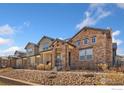 Attractive exterior showcasing stone and siding details, along with meticulous landscaping and a black metal fence at 2748 Prairie Flax St, Berthoud, CO 80513