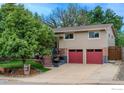 Two-story house with well-manicured lawn and a two car red-door garage at 2850 Emerson Ave, Boulder, CO 80305