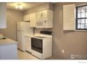 A kitchen featuring white appliances and cabinets, an electric stove, and a window at 2877 Shadow Creek Dr # 303, Boulder, CO 80303