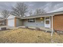 A single-story home with brick and gray siding featuring a two-car garage and front door at 313 Aspen Dr, Brighton, CO 80601