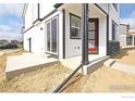 Modern home features a red entry door, white siding and contemporary design elements at 343 Pyramid Peak St, Berthoud, CO 80513