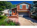 Inviting two-story home featuring a covered porch, brick accents, stone pathway, and a two-car garage at 359 S Jefferson Ave, Louisville, CO 80027