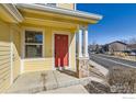 Welcoming front porch with stone accents and a bright red front door, providing a charming entrance at 400 Smith Cir, Erie, CO 80516