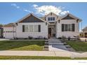 Inviting home facade with landscaped front yard, decorative shutters, and a welcoming entryway with charming details at 405 Buckskin Rd, Berthoud, CO 80513