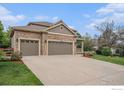 Charming two-story home with stone accents, three-car garage, and well-manicured landscaping at 4910 Crimson Star Dr, Broomfield, CO 80023