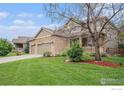 Well maintained home with a large three-car garage, mature landscaping, and covered porch at 4910 Crimson Star Dr, Broomfield, CO 80023