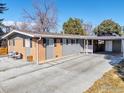 Front exterior view featuring a carport, updated driveway, and brick and wood siding at 4965 Ricara Dr, Boulder, CO 80303