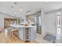 Open kitchen with a large island with seating and stainless steel refrigerator at 4965 Ricara Dr, Boulder, CO 80303