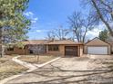 Ranch-style home featuring a brick facade, mature trees, a long driveway and a detached two car garage at 5692 Pioneer Rd, Boulder, CO 80301