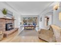 Spacious living room with a brick fireplace, hardwood floors, and ample natural light creating a comfortable gathering space at 5692 Pioneer Rd, Boulder, CO 80301