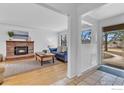 Inviting living room featuring a brick fireplace, light hardwood floors, and an abundance of natural light at 5692 Pioneer Rd, Boulder, CO 80301