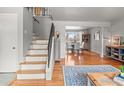 Inviting entryway with hardwood floors, staircase, and open dining area with natural light at 5854 Urban Ct, Arvada, CO 80004