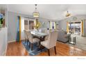 Bright dining area with hardwood floors, stylish seating for six, and an abundance of natural light at 5870 Scenic Ave, Firestone, CO 80504