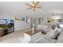 Spacious living room with neutral tones, plush carpeting, and an open layout to the dining area at 5870 Scenic Ave, Firestone, CO 80504