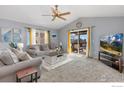 Inviting living room featuring vaulted ceilings, plush carpeting, and a sliding door leading to a deck at 5870 Scenic Ave, Firestone, CO 80504