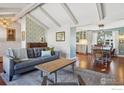 Cozy living room featuring beamed ceilings, hardwood floors, and access to the dining area at 7288 Petursdale Ct, Boulder, CO 80301