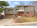 Charming two-story home with a brick facade, mature trees, landscaped front yard, and attached garage at 741 Ithaca Dr, Boulder, CO 80305