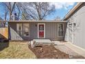 Close up of the front of the house with a red front door and new mulch at 7711 Nikau Dr, Niwot, CO 80503