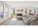 Living room showcasing natural light, a fireplace, and a stylish grey sofa with decorative pillows at 7711 Nikau Dr, Niwot, CO 80503