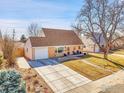 Inviting single-Gathering home boasting a well-kept lawn, long driveway, and attached garage, creating a welcoming curb appeal at 810 Lotus Way, Broomfield, CO 80020